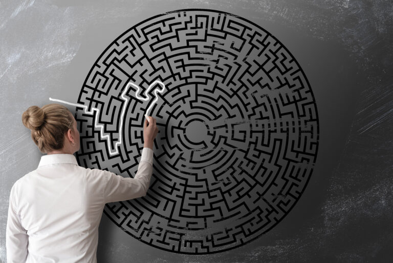 read view of woman trying to find way through chalk drawing of maze on blackboard challenge concept